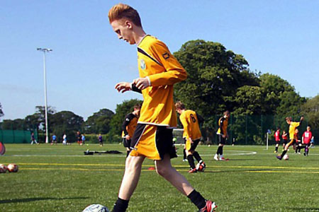 Christleton High School student playing football in PE Kit